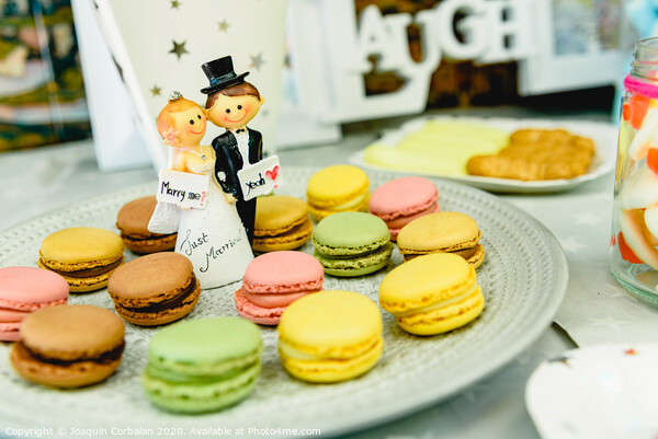 Happy newlywed dolls on a plate with macarons in the candy bar of a wedding. Picture Board by Joaquin Corbalan