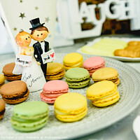 Buy canvas prints of Happy newlywed dolls on a plate with macarons in the candy bar of a wedding. by Joaquin Corbalan