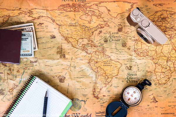 A traveler plans his trip around the world on an old map, while taking notes to get inspired. Picture Board by Joaquin Corbalan