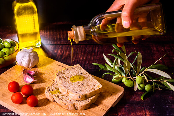 A Mediterranean cook prepares a slice of bread with virgin olive oil, tomatoes and garlic, a traditional breakfast in the Mediterranean countries. Picture Board by Joaquin Corbalan