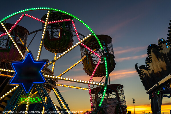 Amusement park at dusk with ferris wheel in the background. Picture Board by Joaquin Corbalan