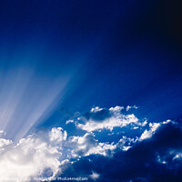 Buy canvas prints of Sunbeams rising from a large cloud in intense blue sky on a summer afternoon by Joaquin Corbalan