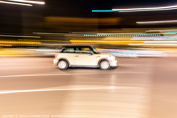 Car rolling at full speed through the city at night, image of panning, with defocused background lights. Picture Board by Joaquin Corbalan