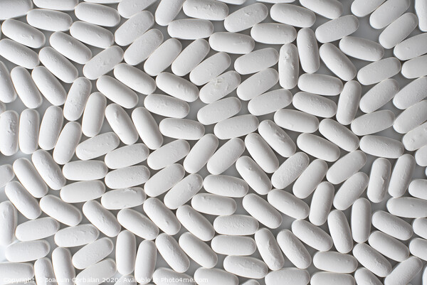 Detail of many white pills of medicines produced by the pharmaceutical and health chemistry industry, seen from above. Picture Board by Joaquin Corbalan