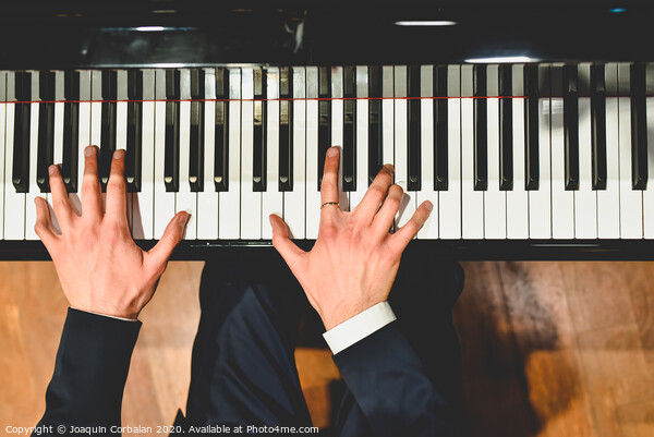 Pianist performing a piece on a grand piano with white and black keys., Seen from above... Picture Board by Joaquin Corbalan