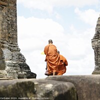 Buy canvas prints of Tibetan monks in orange robes visiting remote Cambodian temples to meditate. by Joaquin Corbalan