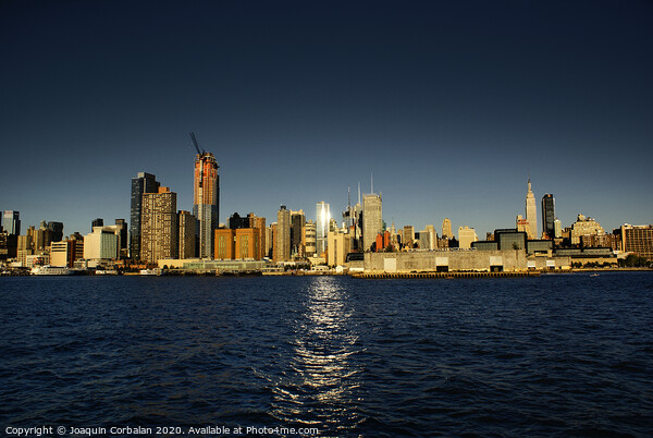 view of Riverside Park next to the city skyline at sunset from the Hudson River. Picture Board by Joaquin Corbalan