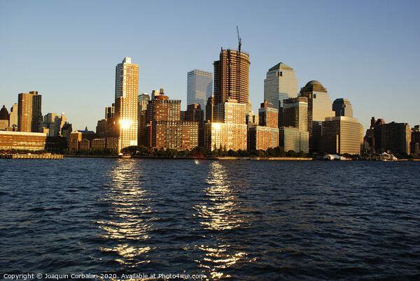  View of Riverside Park next to the city skyline at sunset from the Hudson River. Picture Board by Joaquin Corbalan