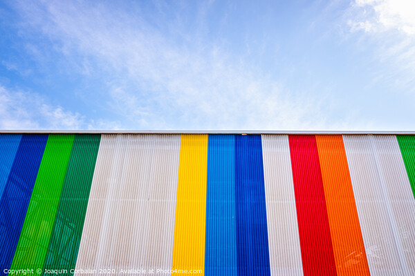Facade with colored lines, against the blue sky in the background. Picture Board by Joaquin Corbalan