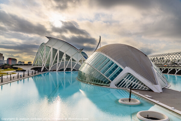 Panoramic cinema in the city of sciences of Valencia, Spain, visited by tourists next to the museum of sciences of the city in the background, at dawn with clouds and sun. Picture Board by Joaquin Corbalan