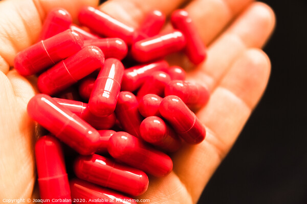 Man's hand holding a handful of medicine pills, to treat addictive diseases Picture Board by Joaquin Corbalan