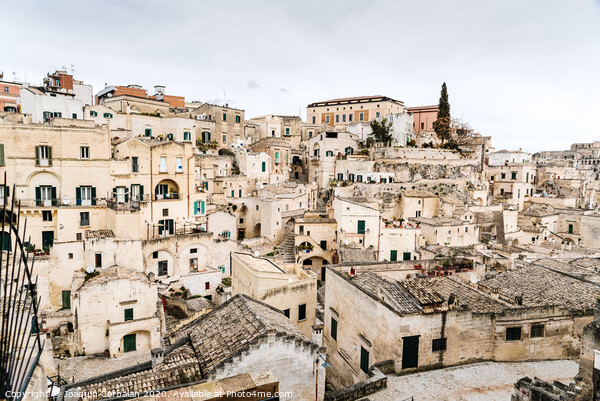 Long panoramic views of the rocky old town of Matera with its stone roofs. Picture Board by Joaquin Corbalan