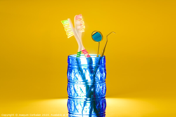 New plastic toothbrushes inside a glass, isolated on bright orange background, with copy space. Picture Board by Joaquin Corbalan