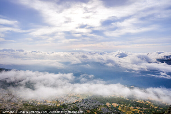 Scene of a winter cloudy sky from the top of a mountain peak. Picture Board by Joaquin Corbalan