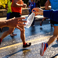 Buy canvas prints of Runner collects a bottle of water to hydrate during a workout. by Joaquin Corbalan