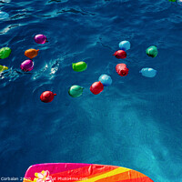 Buy canvas prints of Group of many colorful plastic water balloons floating in the water of a pool to entertain their children on summer vacations. by Joaquin Corbalan