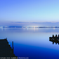 Buy canvas prints of People resting relaxed on a pier on a lake at sunset with calm water by Joaquin Corbalan