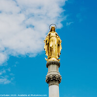 Buy canvas prints of Golden religious statue, illuminated by the sun, of the Virgin Mary on top of a pedestal, with a background of blue sky and clouds. by Joaquin Corbalan
