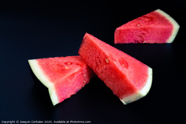 Three slices of watermelon stacked of intense color isolated on black background. Picture Board by Joaquin Corbalan