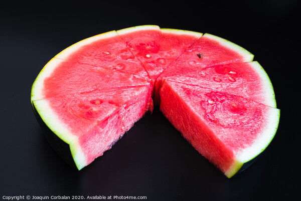 A large slice of watermelon divided into smaller pieces, flat, red, isolated on a black background, as a data chart. Picture Board by Joaquin Corbalan