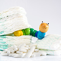 Buy canvas prints of Enterobiasis is a infections of worms, Enterobius vermicularis or pinworms, which affects children and babies. A toy worm with some diapers and pills. by Joaquin Corbalan