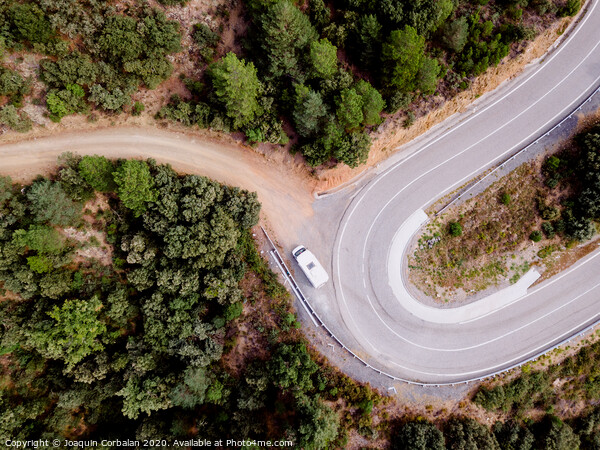 Aerial view of an adventure travel motorhome on a mountain road through a forest Picture Board by Joaquin Corbalan