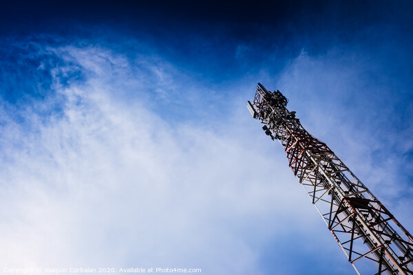 A tall modern communications tower provides telecommunications service to a city, negative space on blue background. Picture Board by Joaquin Corbalan