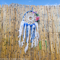 Buy canvas prints of Vintage indigenous decoration hanging from a wall of old reeds, intense colors. by Joaquin Corbalan