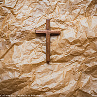 Buy canvas prints of Simple wooden religious cross on brown paper background. by Joaquin Corbalan