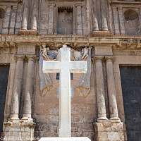 Buy canvas prints of Cross carved in white stone, erected in front of a Christian religious church. by Joaquin Corbalan
