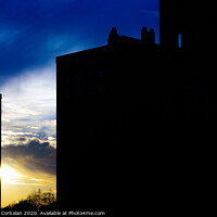 Buy canvas prints of Sunset silhouette in a city with the warm sun behind buildings. by Joaquin Corbalan