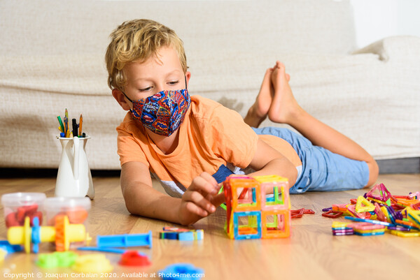 Young child plays at home with mask while recovering from covid infection. Picture Board by Joaquin Corbalan
