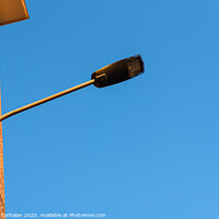 Buy canvas prints of Lamppost on the red wall of a building, by day, with a blue sky background. by Joaquin Corbalan