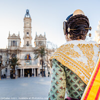 Buy canvas prints of Woman dressed as a Fallera with her back turned, observes the facade of the Valencia City Hall, out of focus in the background. by Joaquin Corbalan