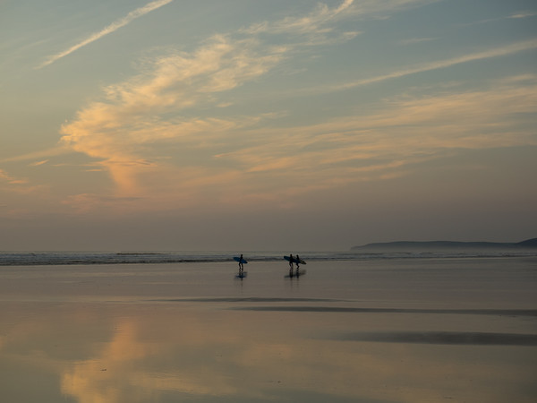 Surfers heading out to sea at Westward Ho in Devon Picture Board by Tony Twyman