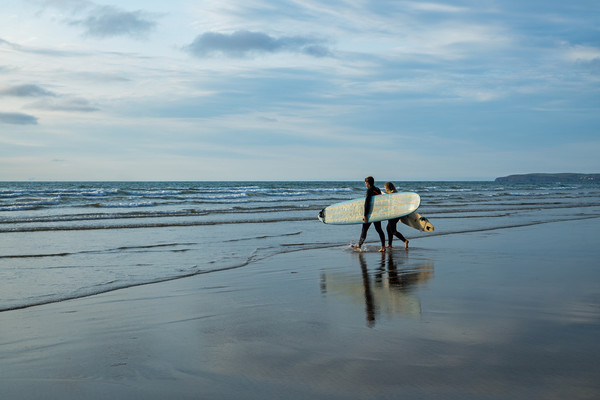 Surfer couple entering the sea at Westward Ho! Picture Board by Tony Twyman