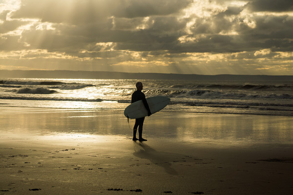 Surfer watching the waves at Croyde Bay in Devon Picture Board by Tony Twyman