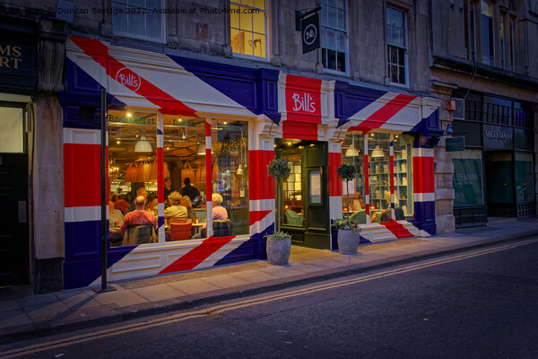Bill's restaurant at dusk decorated in the Great Britain flag  Picture Board by Duncan Savidge