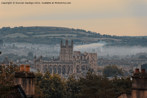 Moody early morning mist rising behind Bath Abbey Picture Board by Duncan Savidge