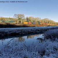 Buy canvas prints of Freightliner passes the white frozen landscape of the river Avon near Freshford by Duncan Savidge