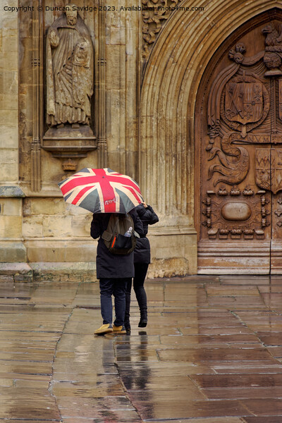 Union jack umbrella outside Bath Abbey Picture Board by Duncan Savidge