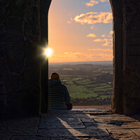 Buy canvas prints of Sunset through the arch at Glastonbury Tor by Duncan Savidge