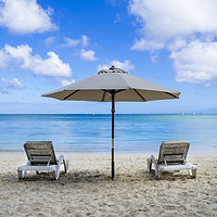 Buy canvas prints of Two sun loungers and parasol on beach by Mehul Patel