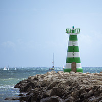 Buy canvas prints of Sailboats speed past Vilamoura Lighthouse, Portuga by Rehanna Neky