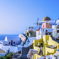 Buy canvas prints of At dusk the sun bathes the traditional and colorful Greek houses in the town of Oia by Mario Koufios