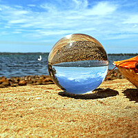 Buy canvas prints of Glass orb on seashore by Martin Smith