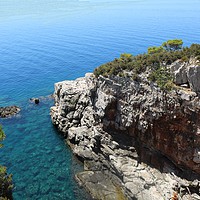 Buy canvas prints of Rockface and bay on Lokrum island by Andrew Reece