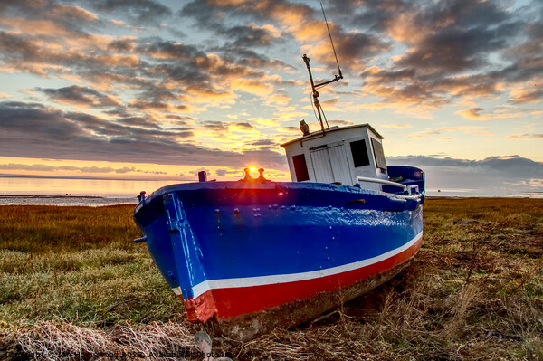 Fishing boat at sunset Picture Board by Ian Homewood