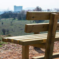 Buy canvas prints of close empty wooden bench in spring park over the city by David Galindo