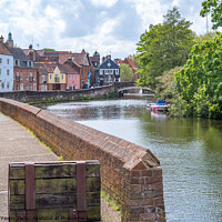 Buy canvas prints of Norwich, Norfolk, UK – May 11 2021. The historic Quayside along the River Wensum in the city of Norwich, Norfolk. The traditional properties along this pedestrianised road have stunning interrupted views across the River Wensum all the way to Fye Bridge by Chris Yaxley